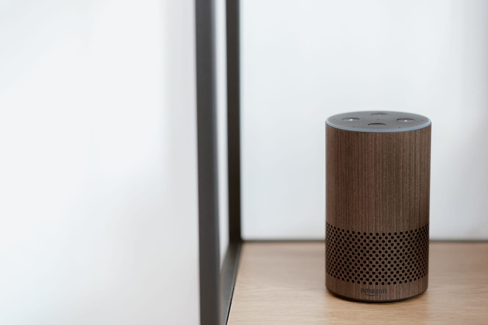 A smart bulb in a lamp beside a smart speaker