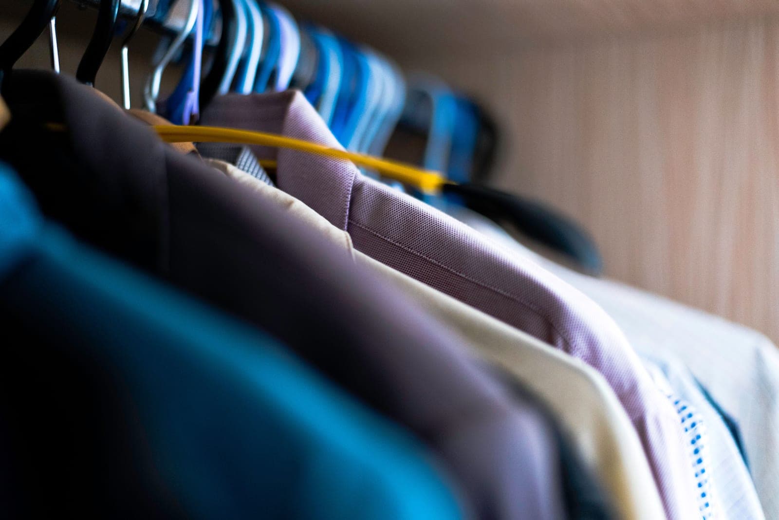 A clothes closet lit by a small battery light bar