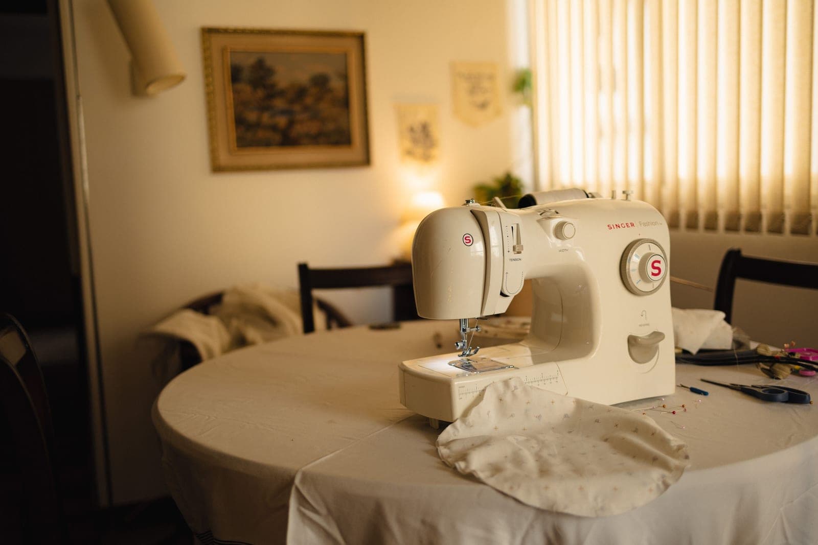 A sewing table lit by an adjustable task lamp