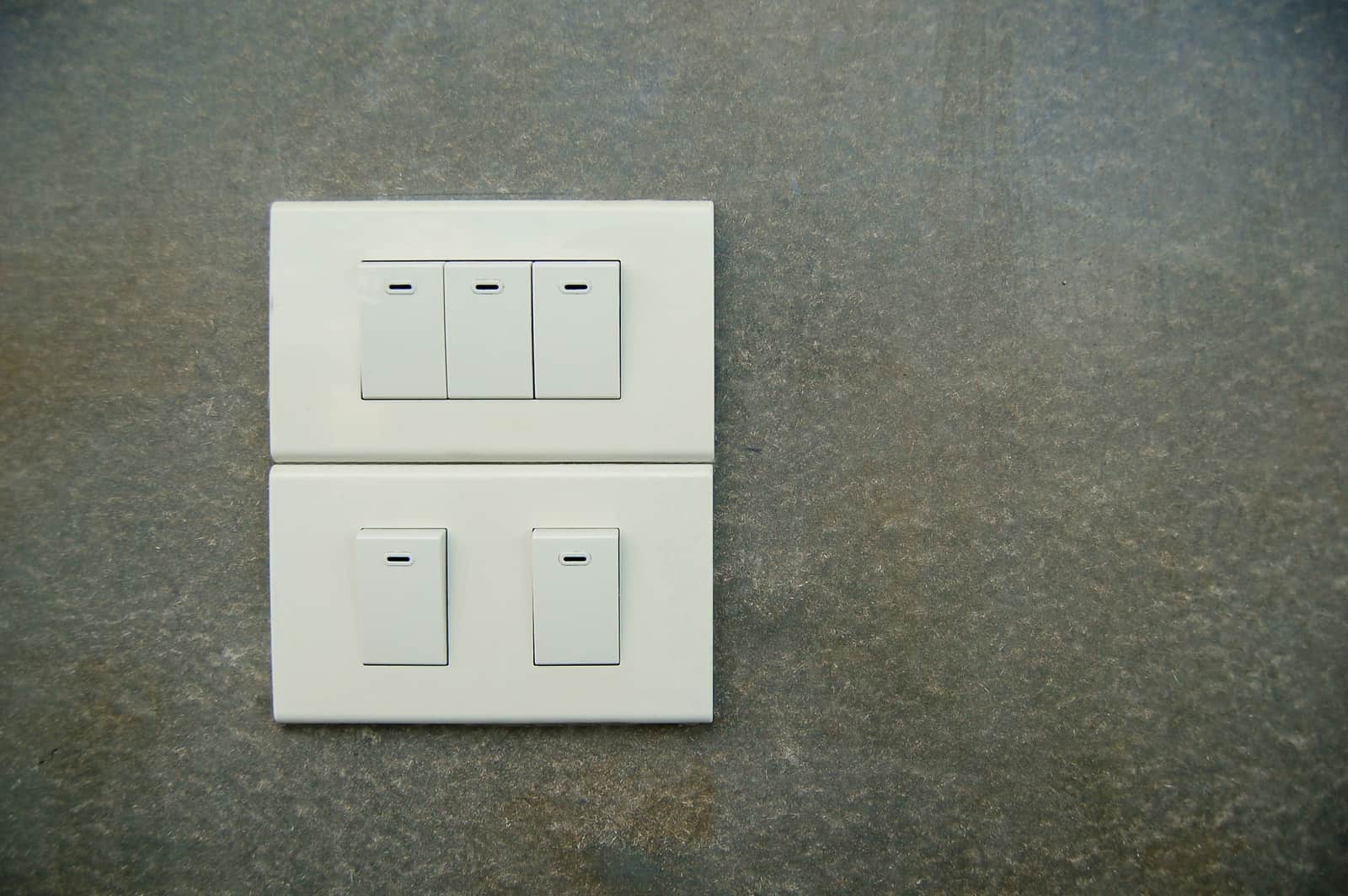 A wall dimmer switch beside a softly lit room
