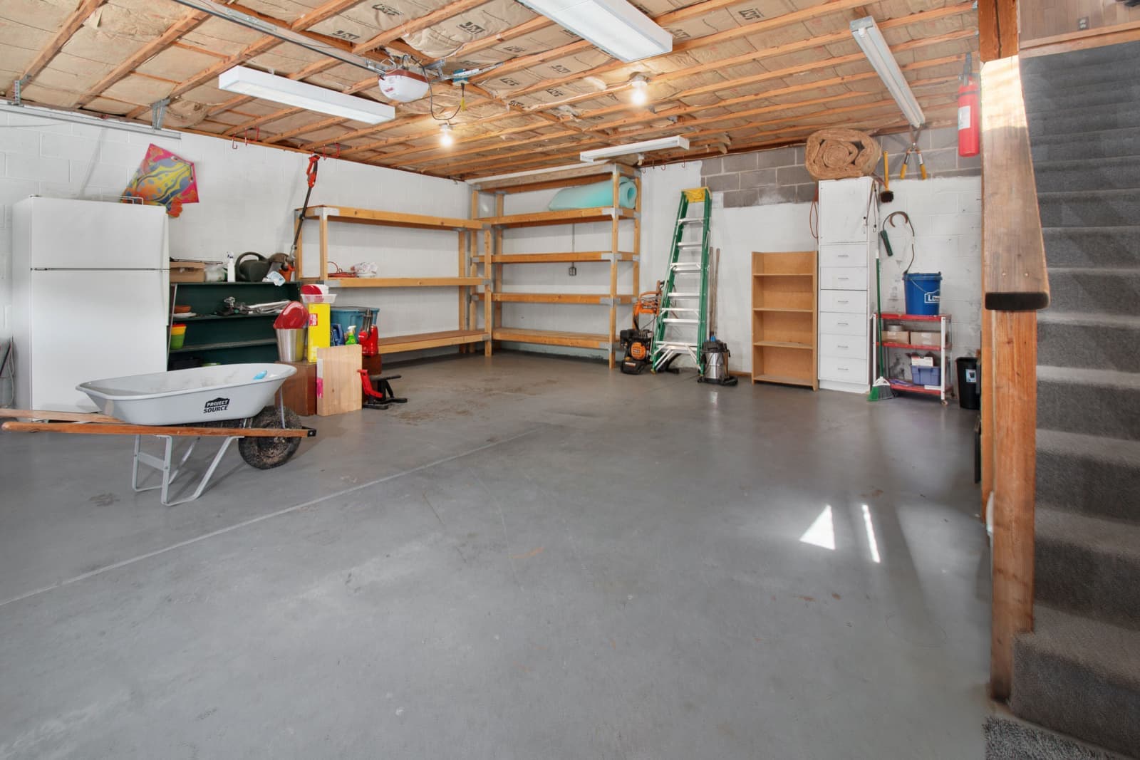 A garage workspace lit by linear ceiling fixtures