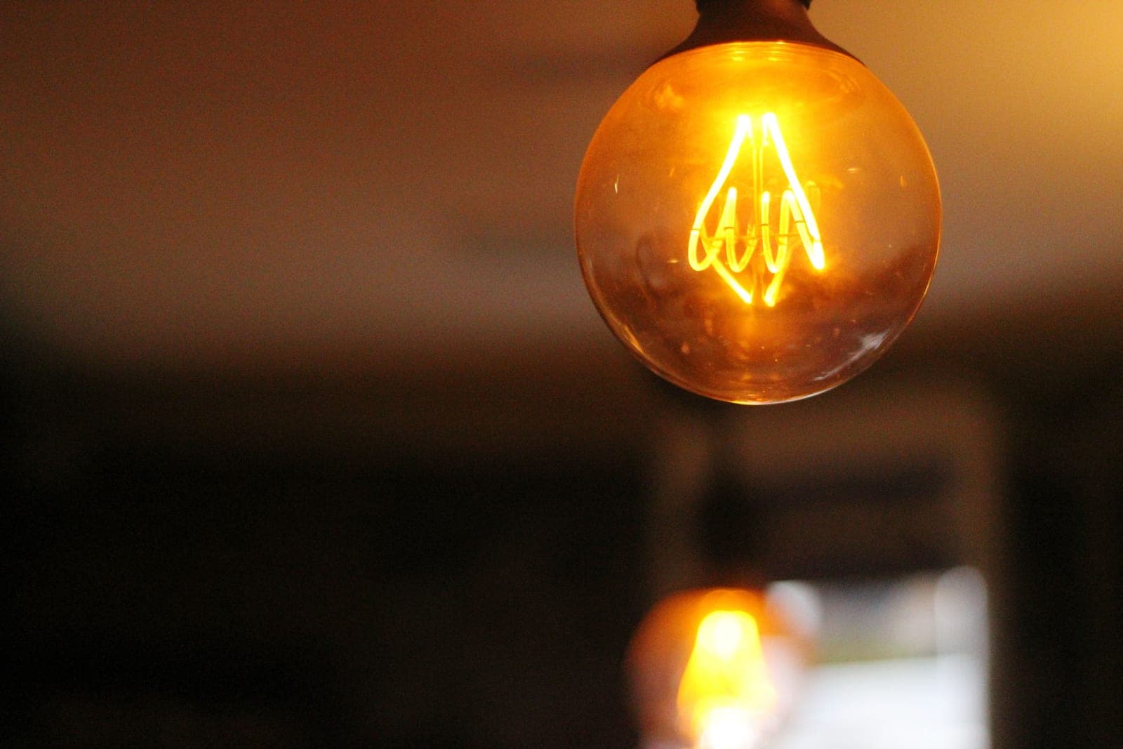 A bare bulb producing harsh glare against a dark wall