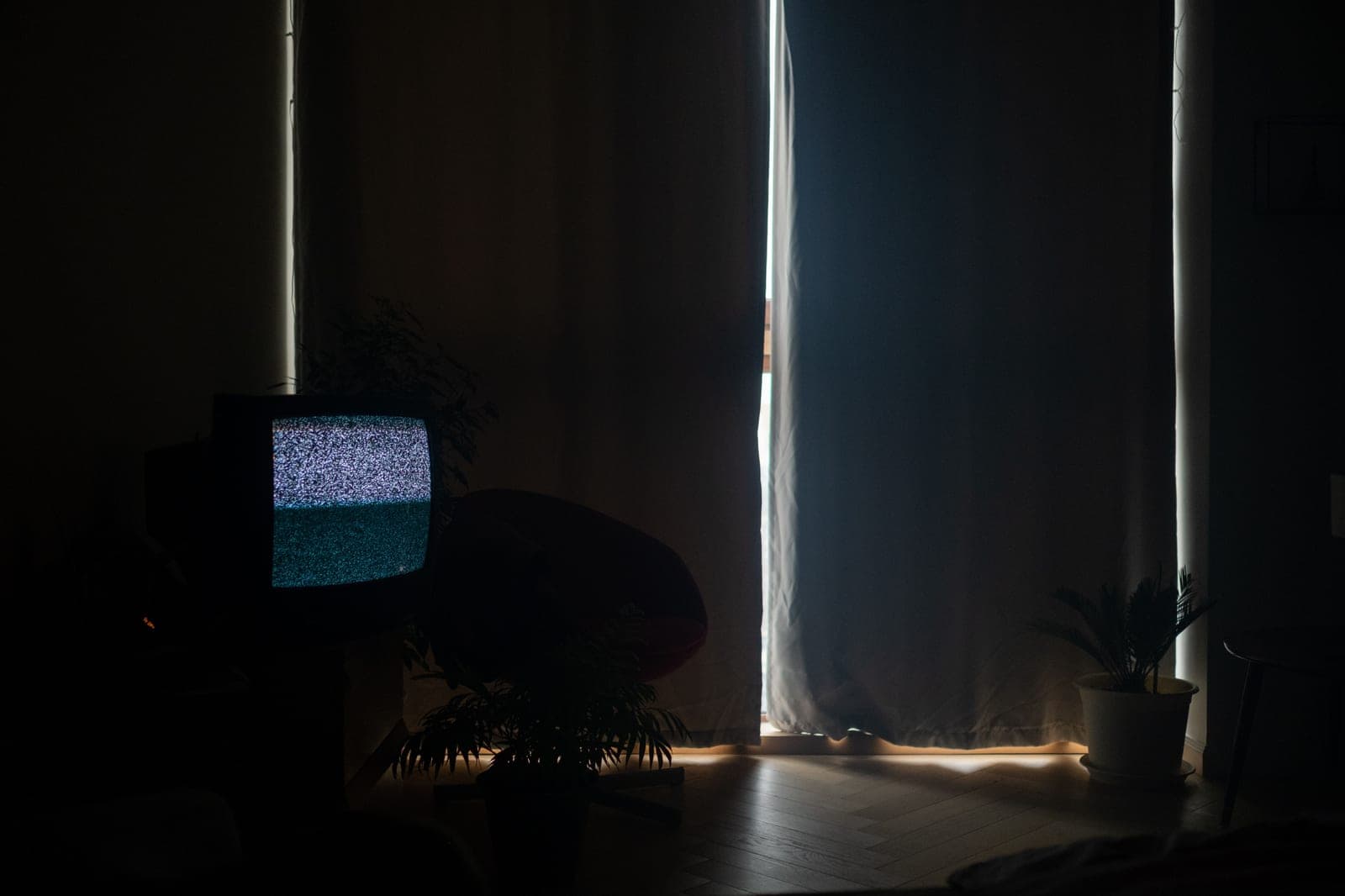 A television with soft bias lighting behind it in a dark room