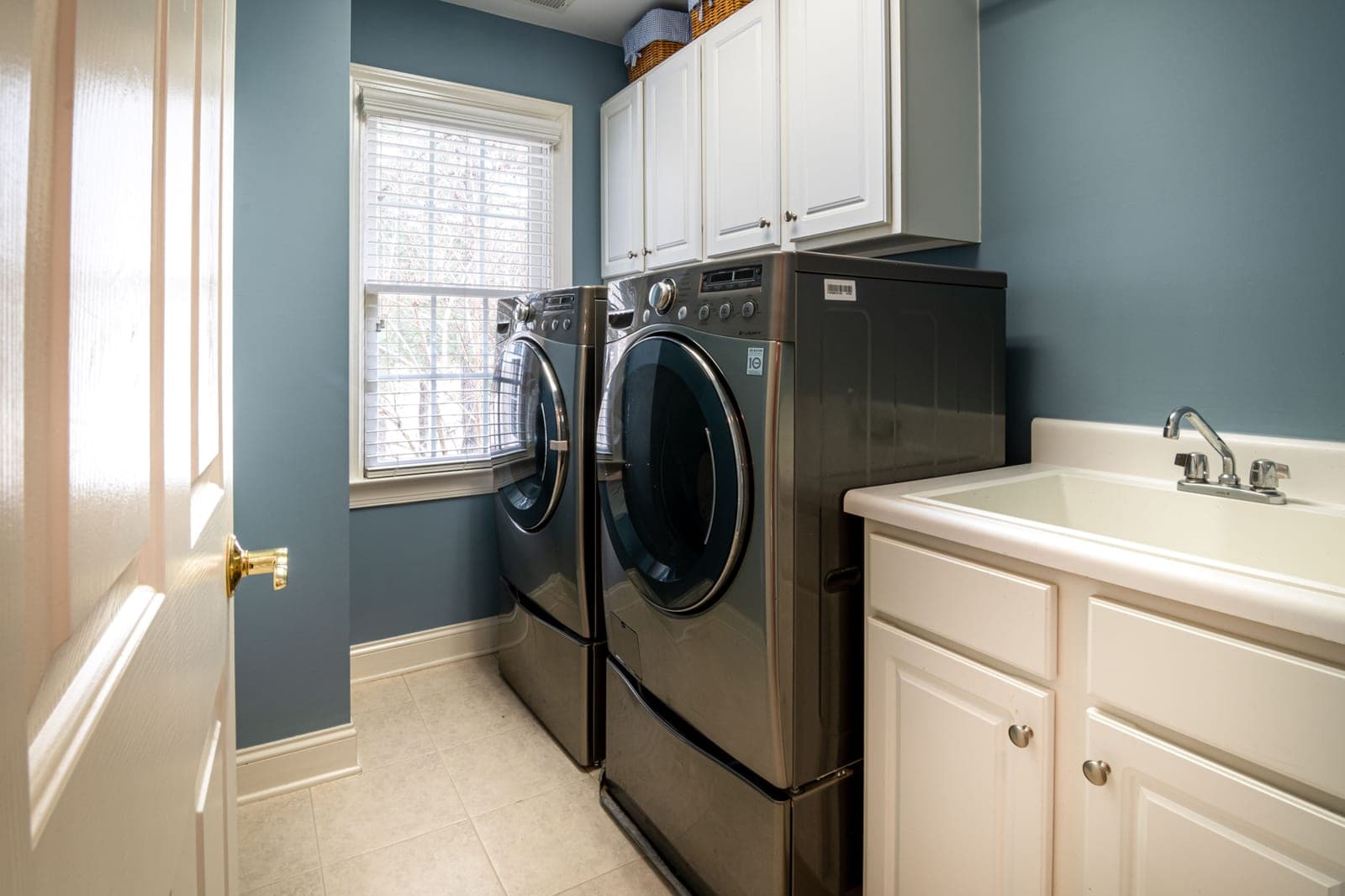 A small laundry room with a washer and dryer lit from above