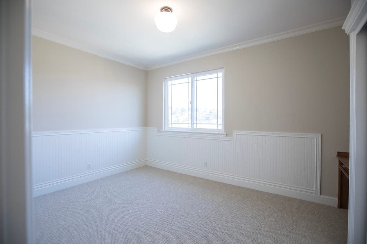 A bare bright ceiling light in a plainly furnished room