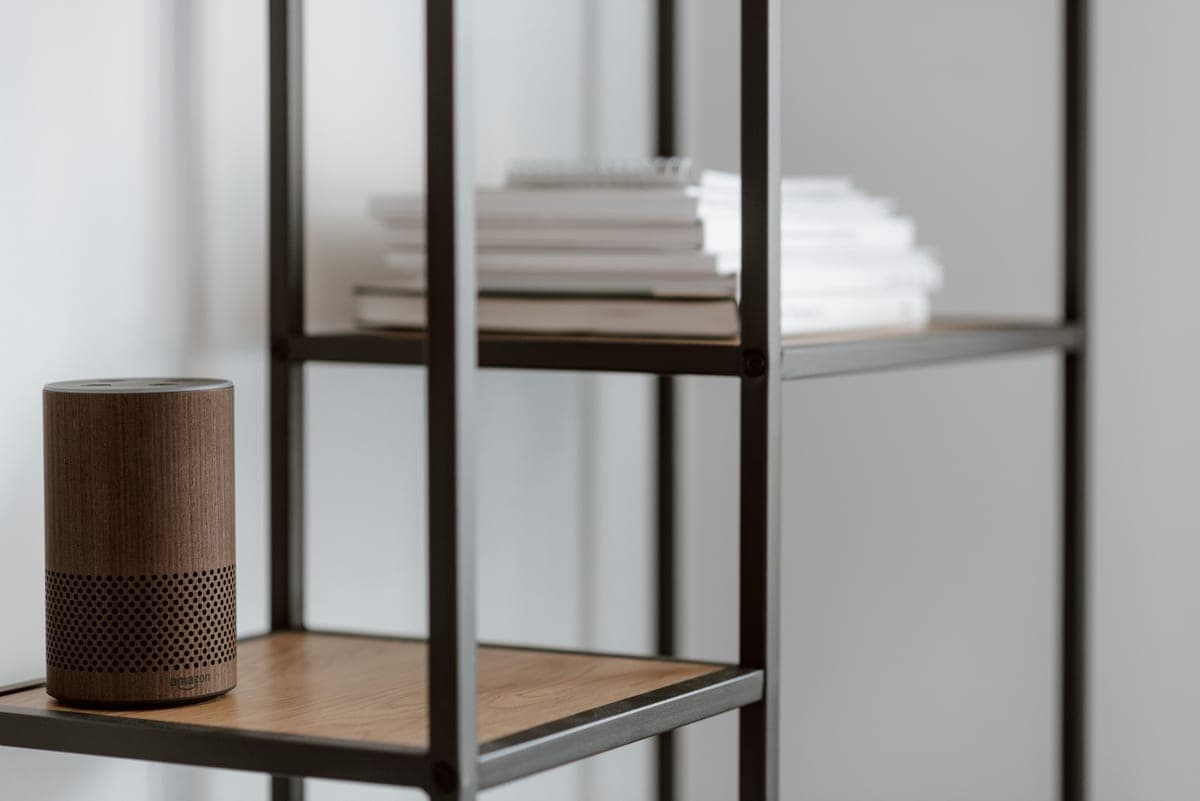 Smart home devices on a shelf beside a lamp