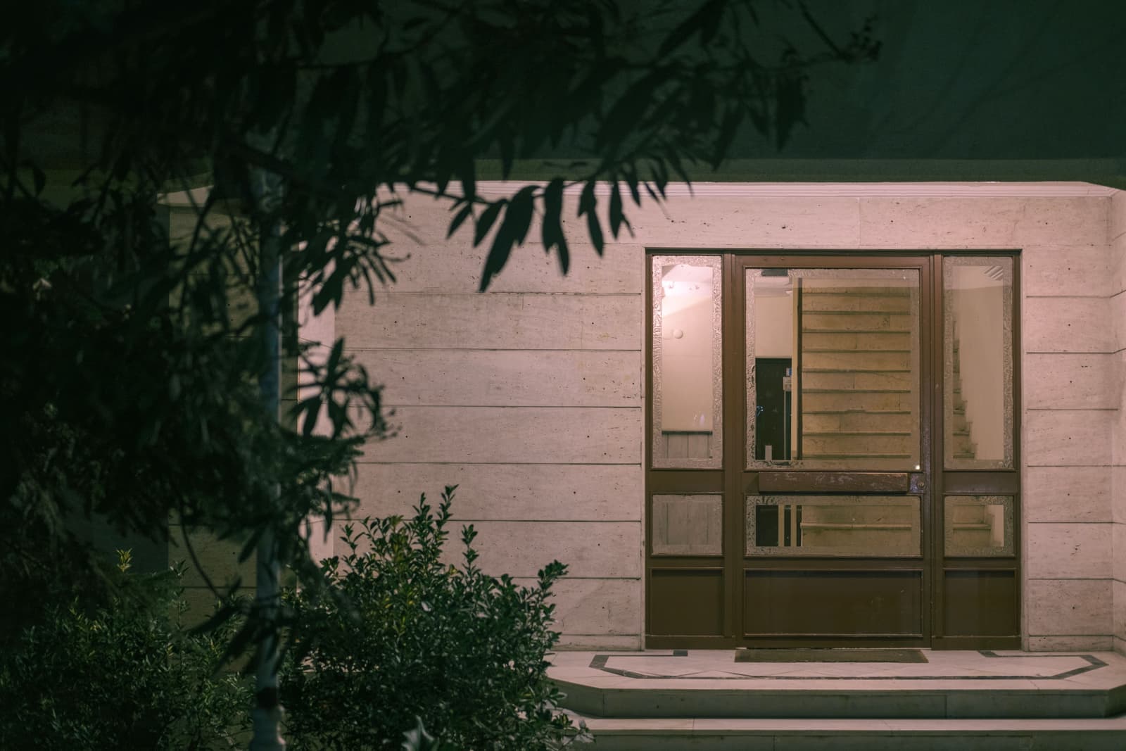 A porch light beside a front door at night