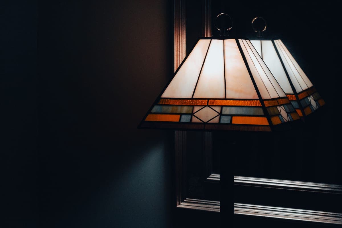 A living room in the evening with several lamps lit at different heights