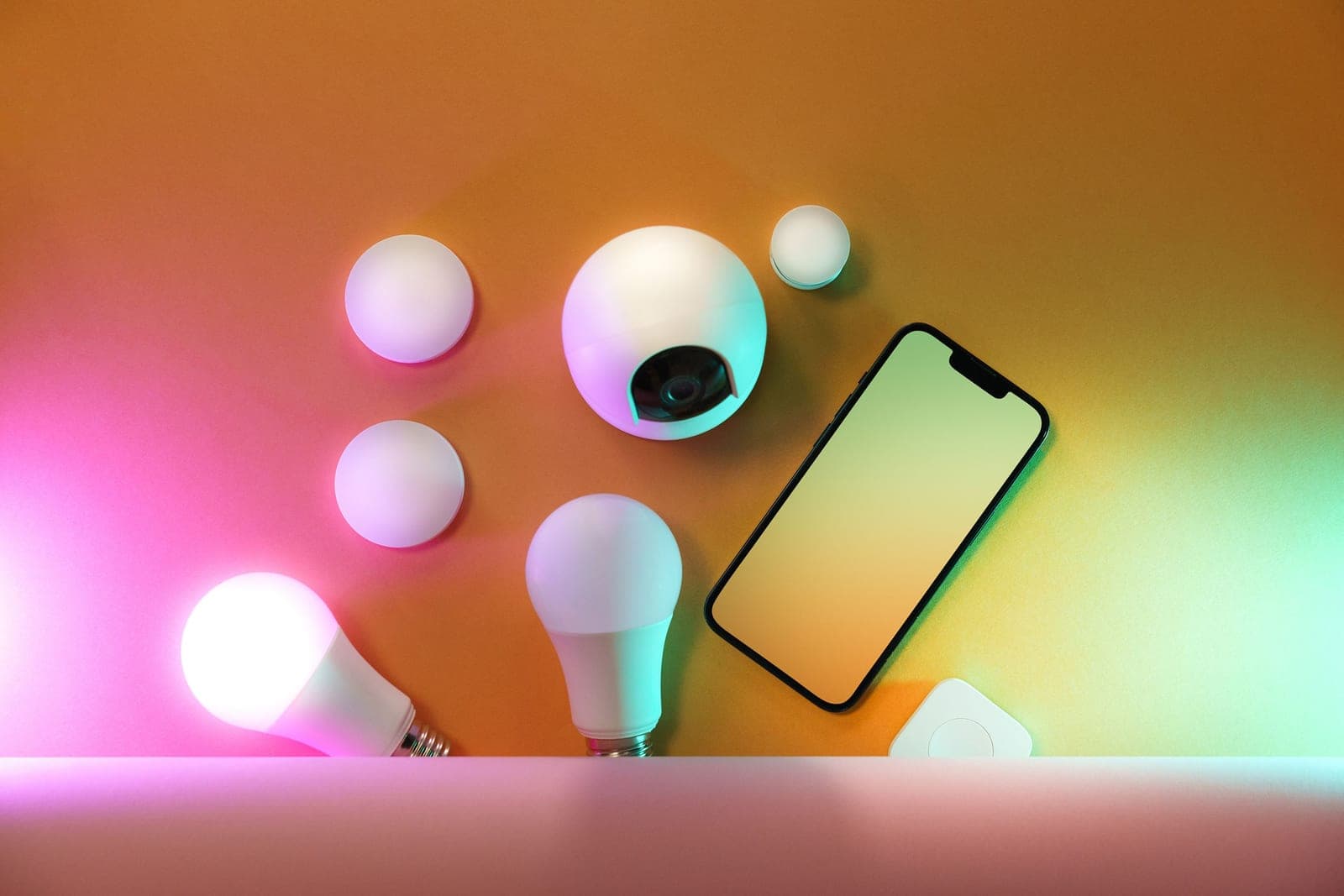 A phone showing a lighting schedule beside a warmly lit lamp