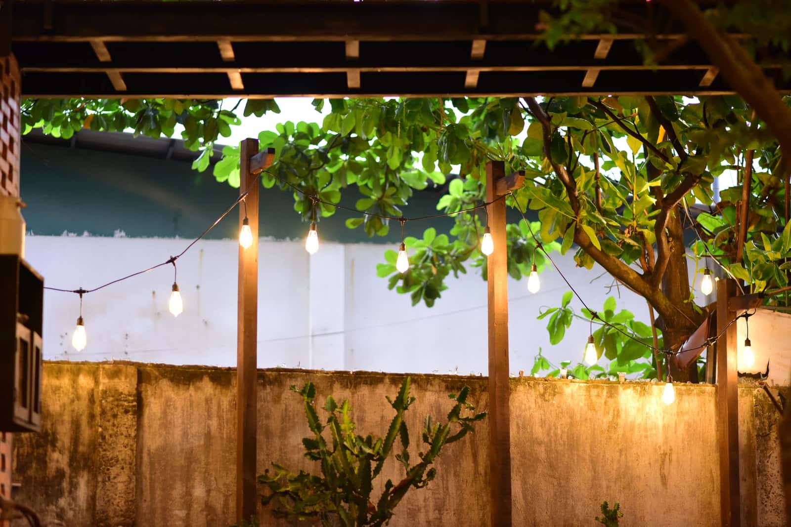 Warm string lights hung above a patio at dusk