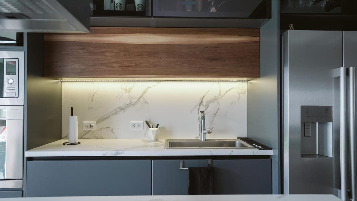 An LED strip fitted along the underside of a kitchen cabinet