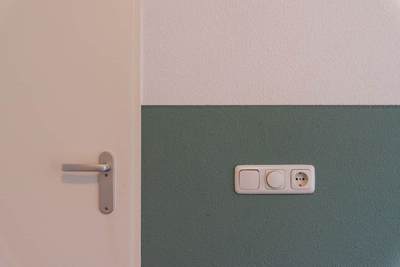 A wall outlet beside a light switch in a living room