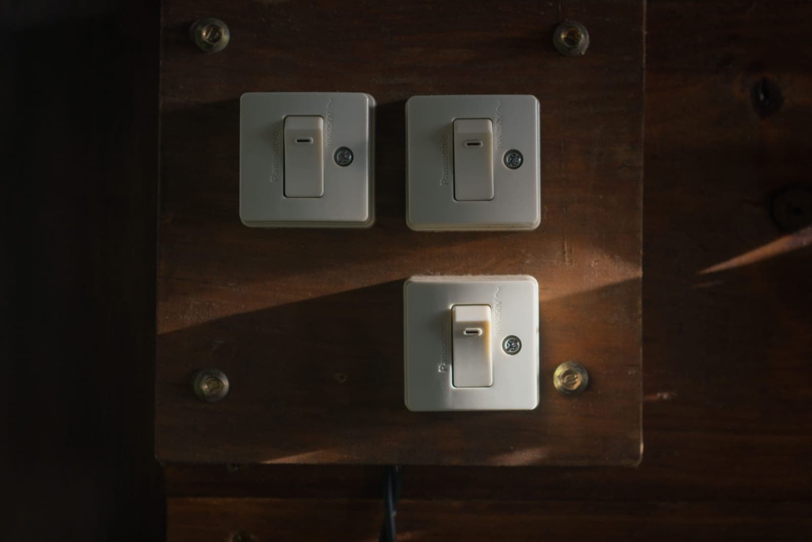 A light switch plate at the bottom of a staircase