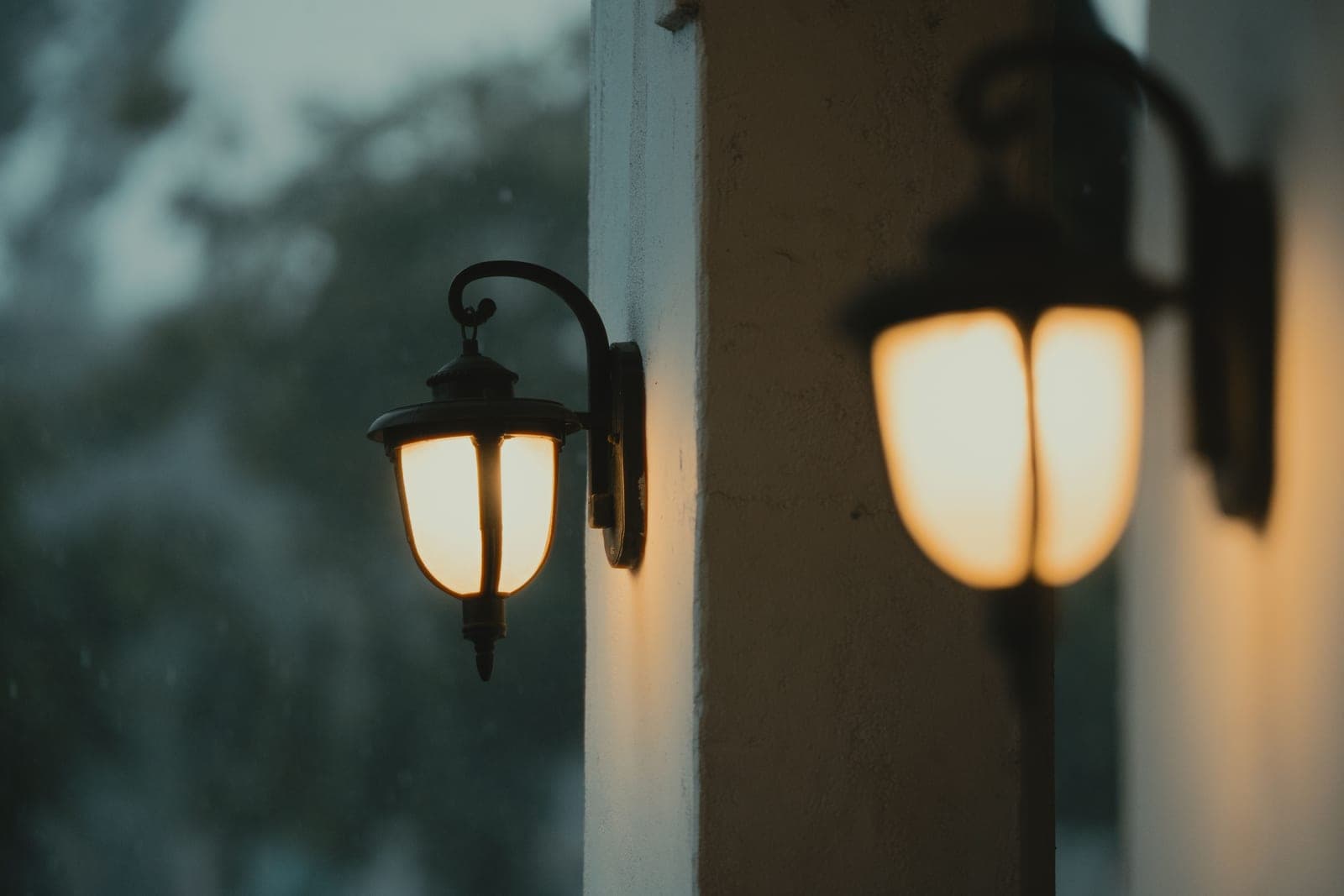 An outdoor light fitting under a covered porch in the rain